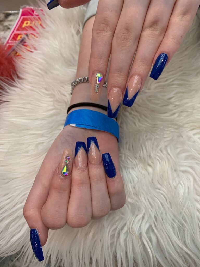 Striking blue and nude nail design with holographic accents from The Grand Nails of America, capturing the essence of Houston's nail art scene.